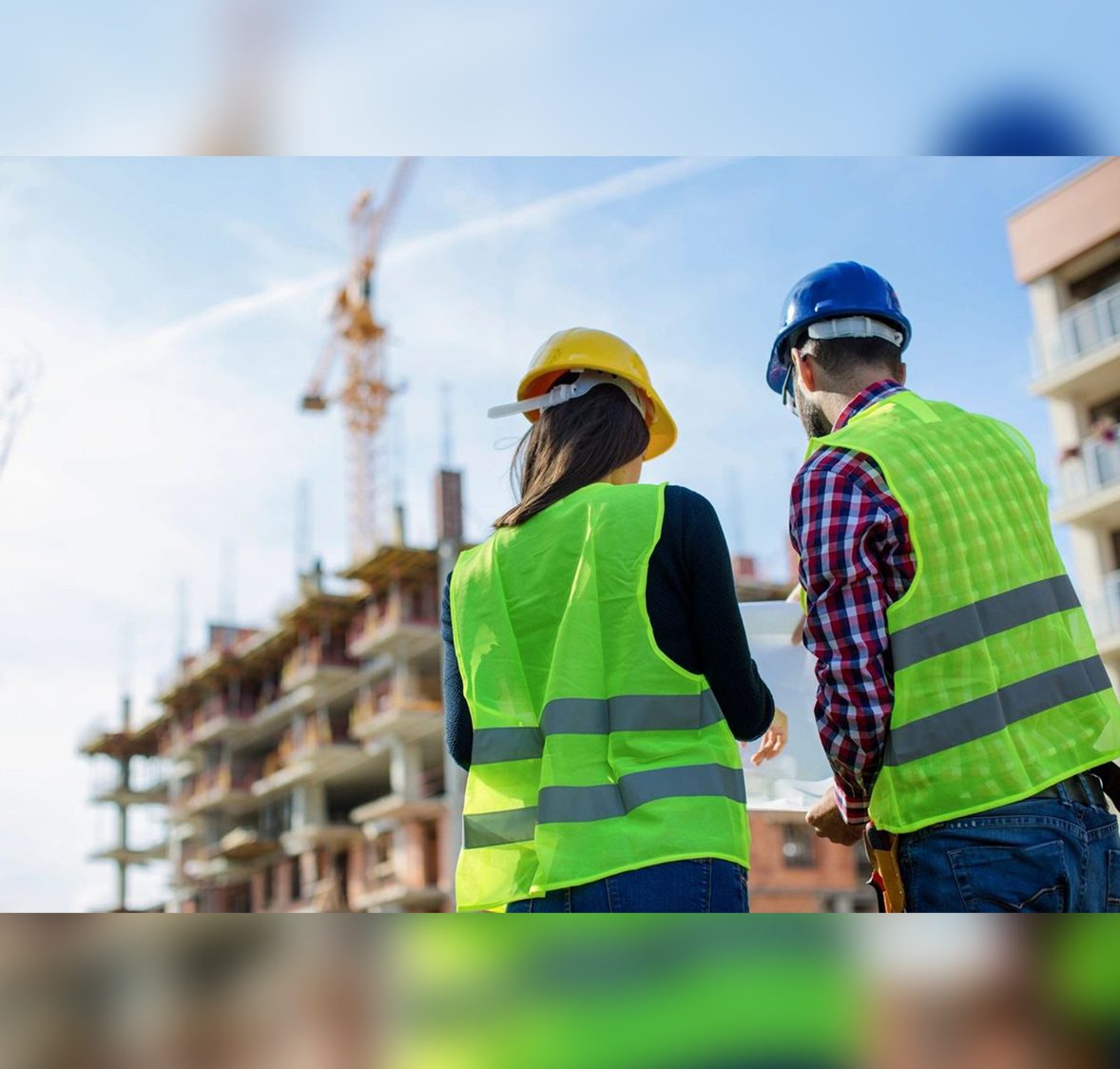 0a1 Two people in safety vests and hard hats on a construction site.