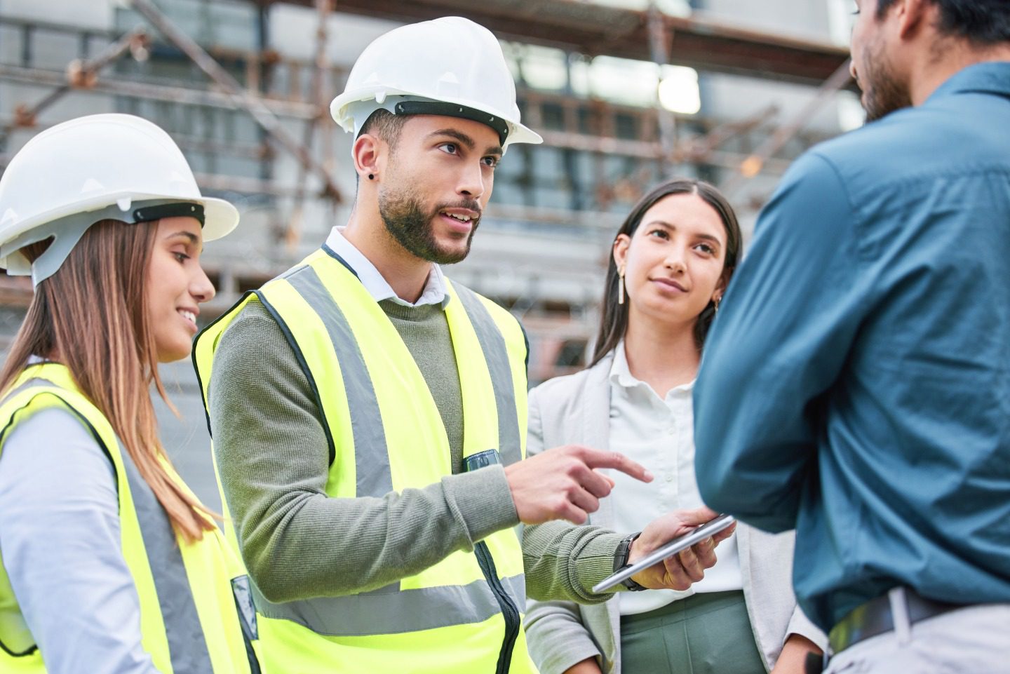 Construction team discussing at building site.