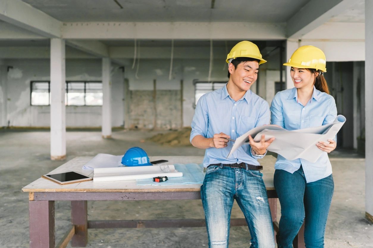 fm=f_V8eGwO7 Two men in hard hats are sitting on a bench.